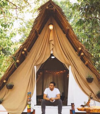 mid-adult-man-sitting-entrance-glamping